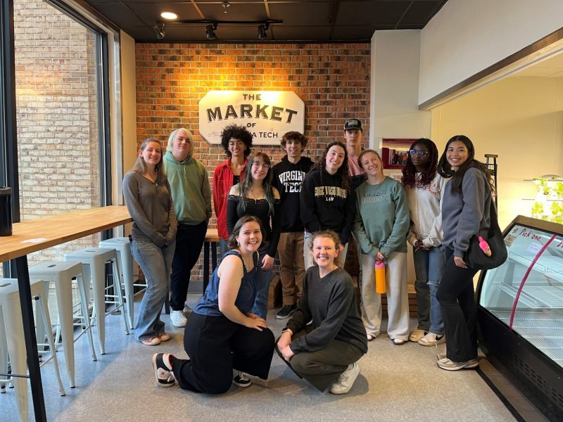 Justice Challenge students pose in front of a sign that reads "The Market of Virginia Tech"