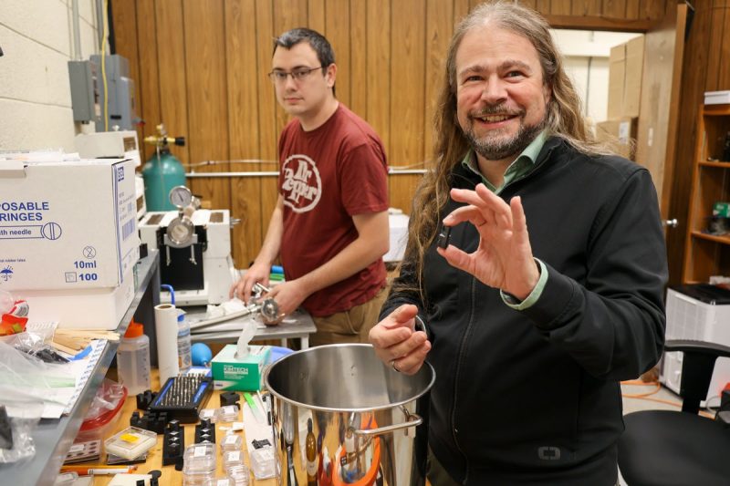 Patrick Huber in foreground holding up a crystal. Keegan Walkup in background.