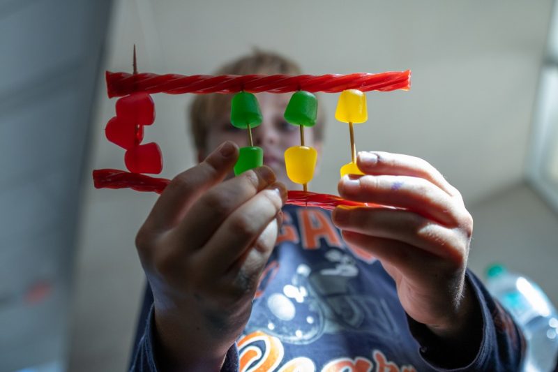 Young boy holds a DNA sequence made of candies.
