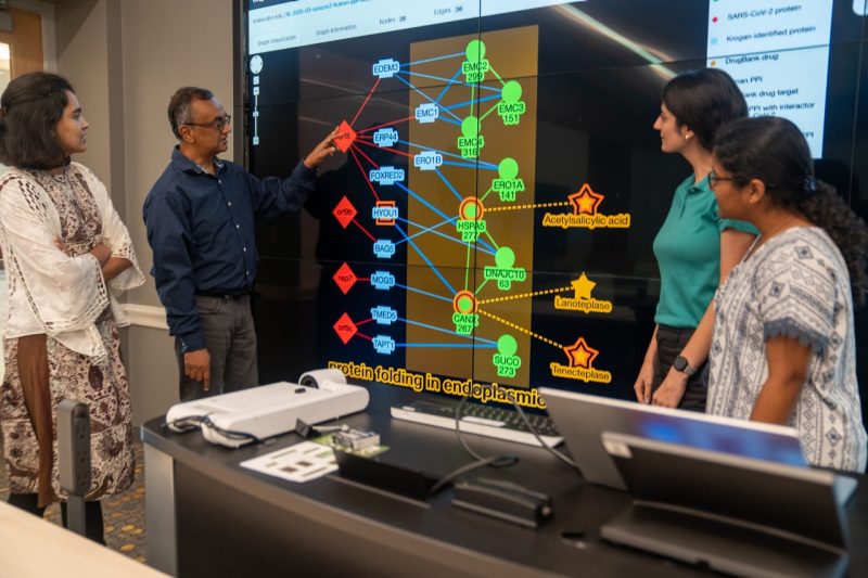 computer science team at work in front of big screen