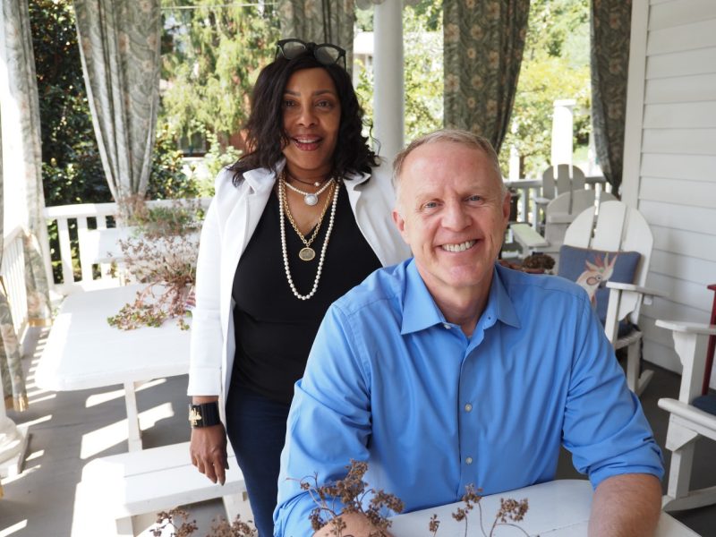 Man and woman sit together on porch.