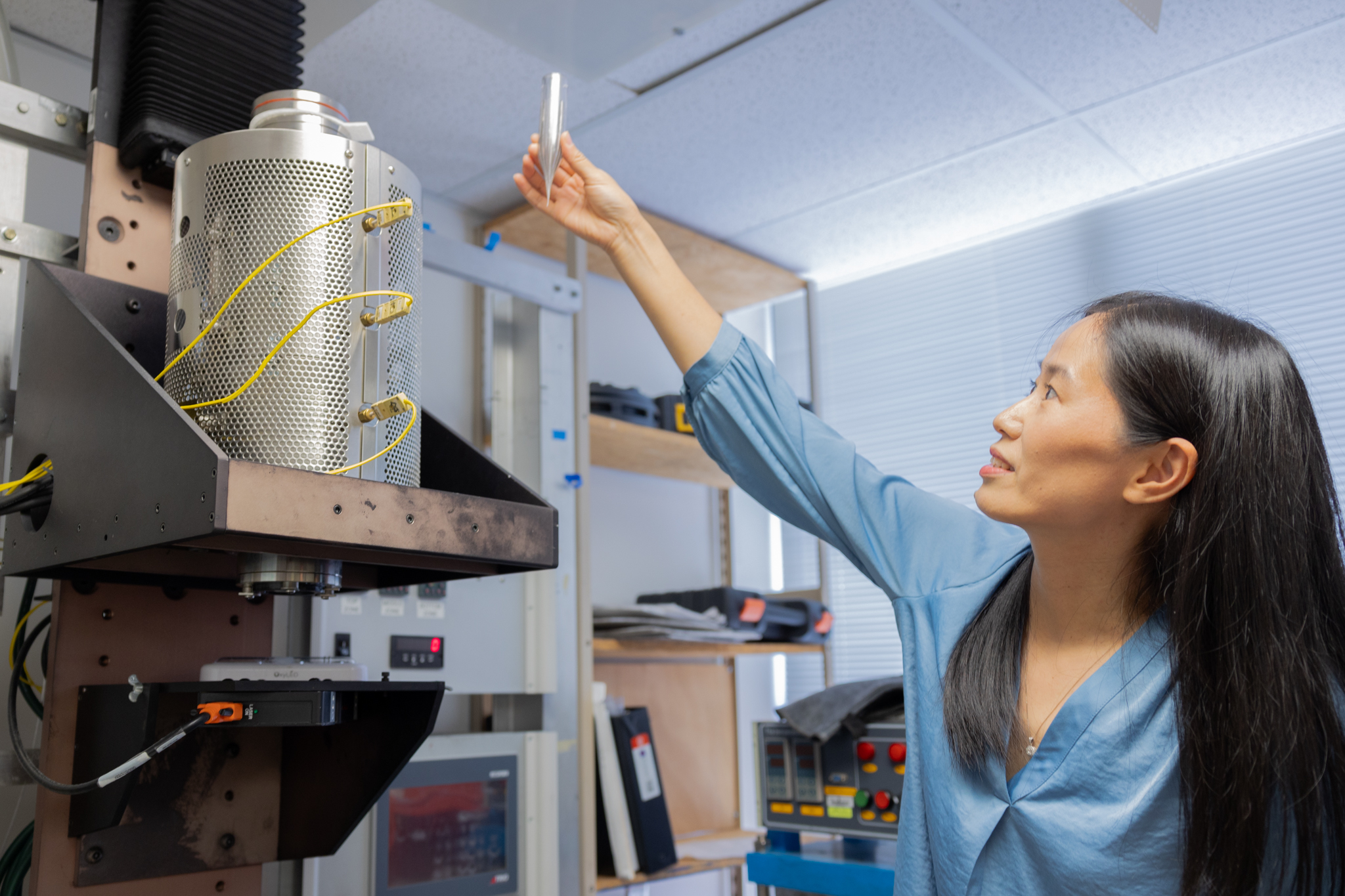 Virginia Tech faculty member holds up test tube in lab.