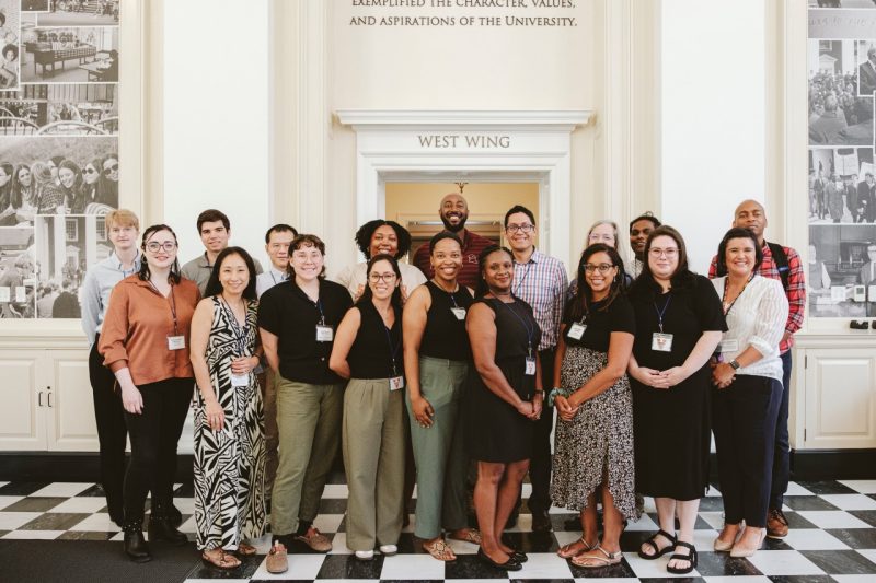 A group of resident librarians pose for pictures in a lobby.