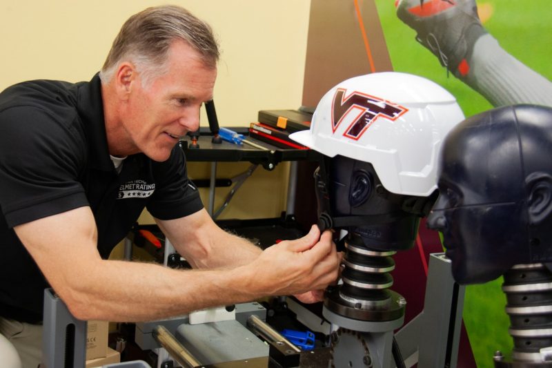Barry Miller in Virginia Tech Helmet Lab with safety helmet on test rig.