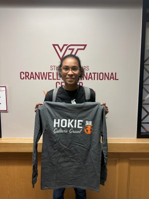 A woman holds up a Hokie Culture Crawl shirt