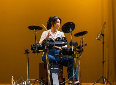 Female drummer performs on stage