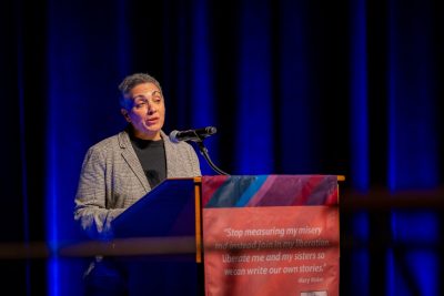 Dean Belmonte speaks at the podium in the Moss Arts Theater