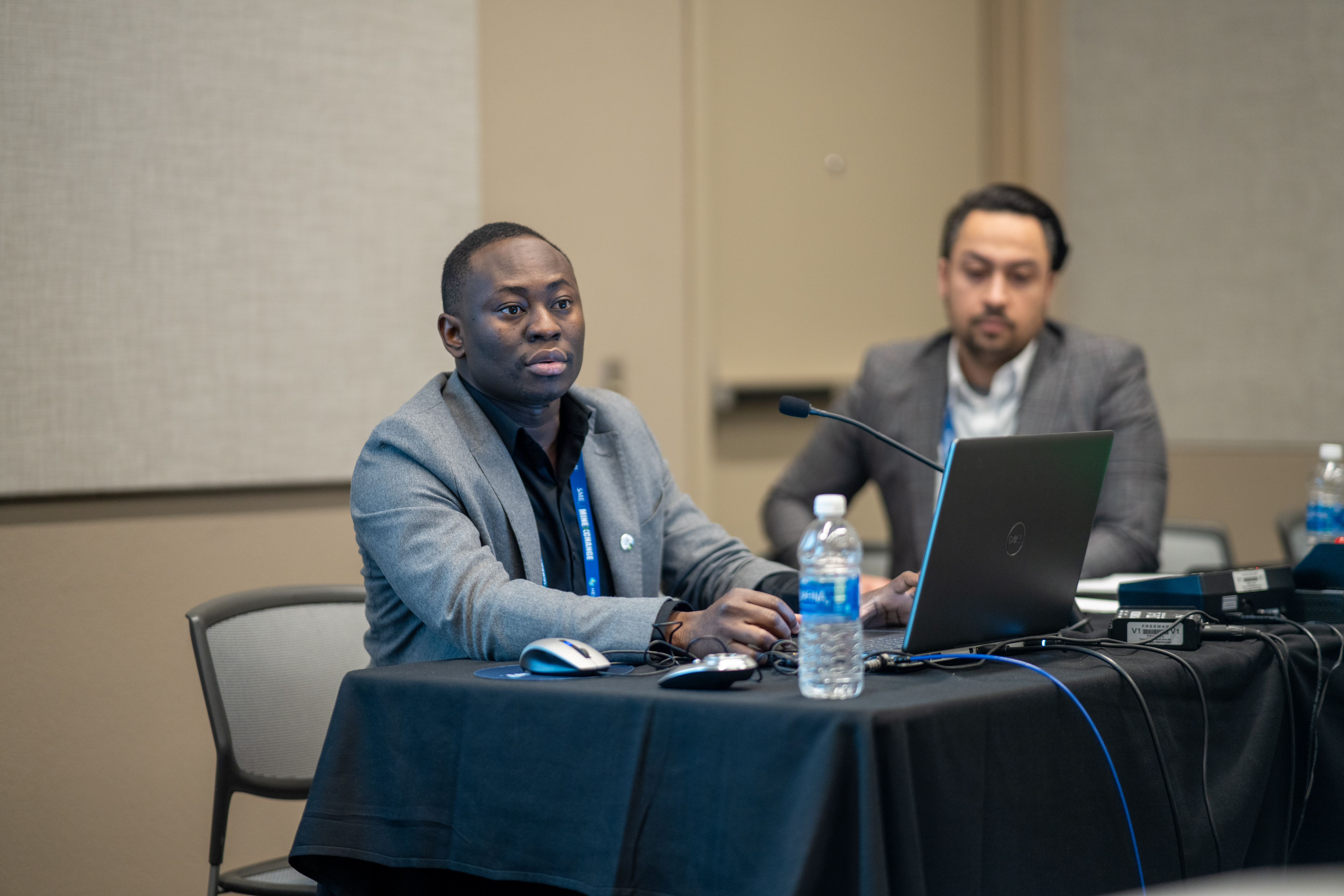 Festus Animah sitting at a table at the conference session.