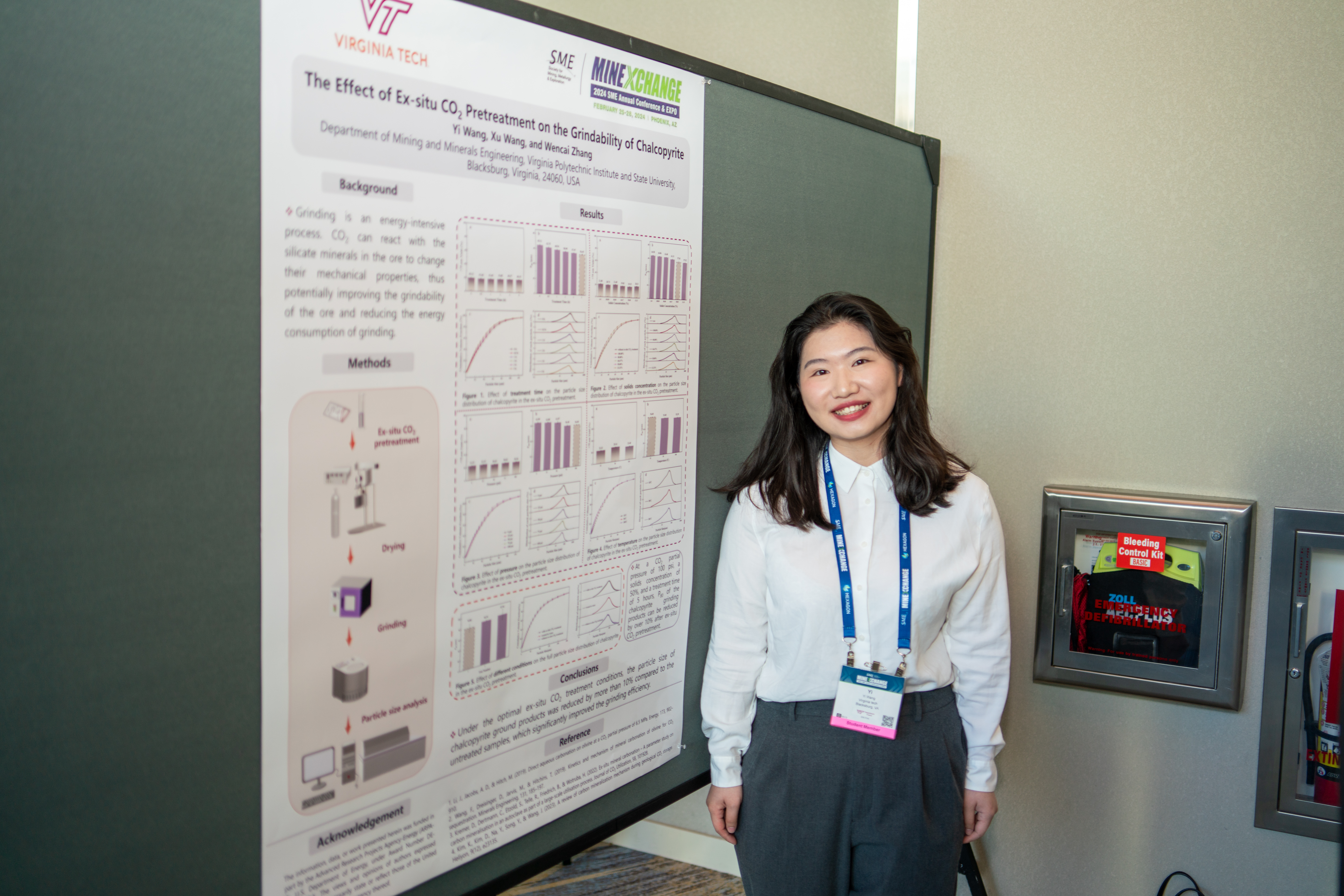 Student Yi Wang standing in front of her poster.