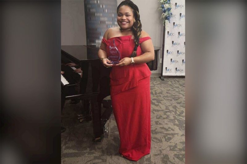 Monet Roberts holds the Henrietta Lacks Legacy award that she received earlier this mont