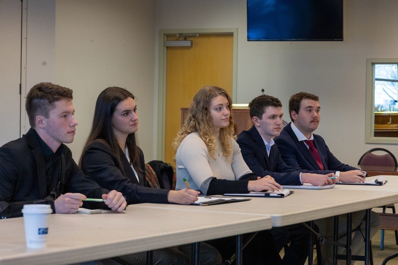 A group of students sit at a table.