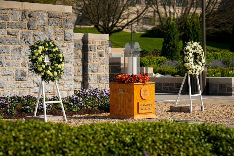 The ceremonial candle is flanked by two wreaths at the April 16 Memorial.
