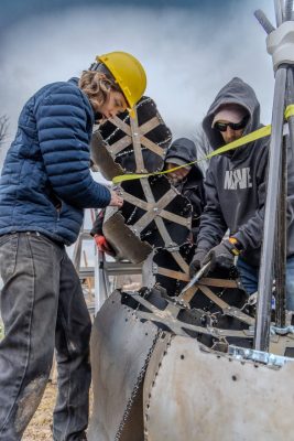 Braden Perryman (at left), Rude Graves (at center) and Damon Brewer (at right) secure upper segments of Emergence using internal bracing. Photo by Trevor Finney for Virginia Tech.