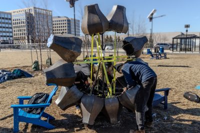 Damon Brewer (at left), Rude Graves (at center) and Braden Perryman (at right) secure midsection components of Emergence using support straps and steel framing. Photo by Trevor Finney for Virginia Tech.