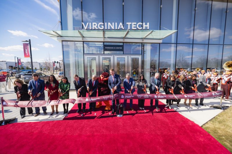 People cut a ribbon marking the entrance to a new building.