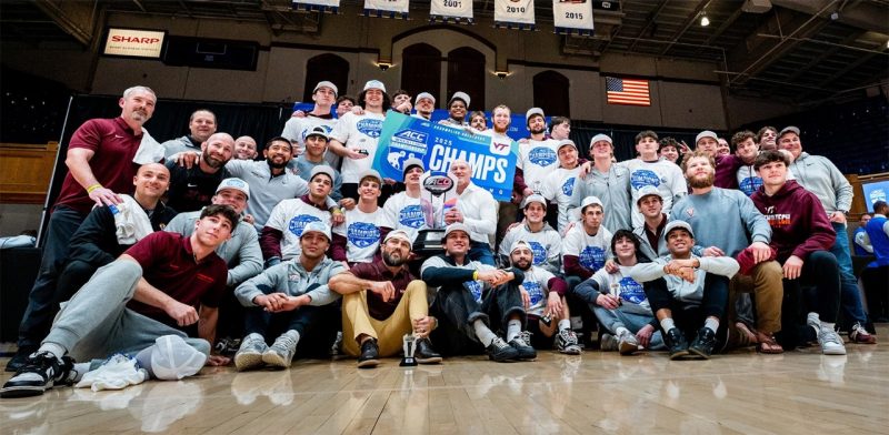 Members of the Virginia Tech wrestling team pose with a trophy for winning the ACC championship.