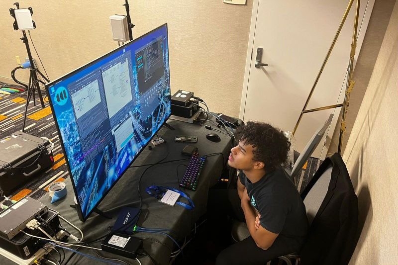 Young man looks a research results on computer screen at Milcom