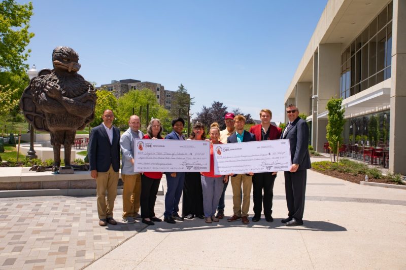 Members of the Montgomery County Emergency Assistance Program, the Virginia Tech Dean of Students, and Sigma Phi Epsilon with Flex out Hunger contributions in front of Dietrick Dining Center. Photo By Darren Van Dyke..