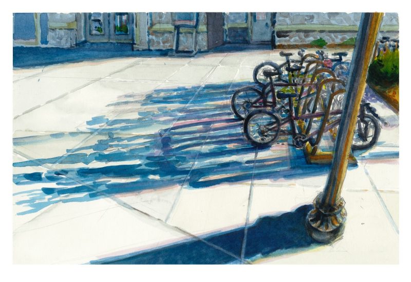 A bike rack with long shadows from the end of the day sunlight