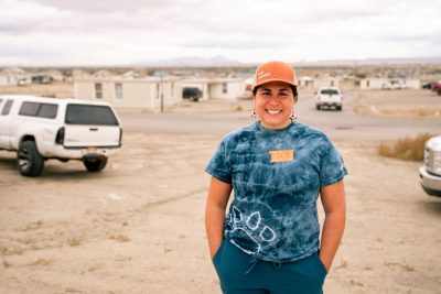 Lindsey Buracker posing in front of homes in the Navajo Nation