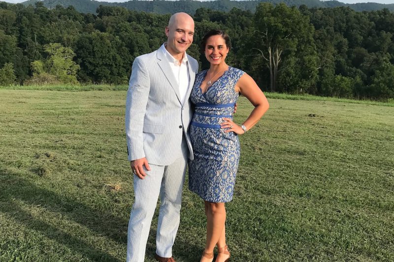 Rebecca Persons (at right) standing with a man in a field.