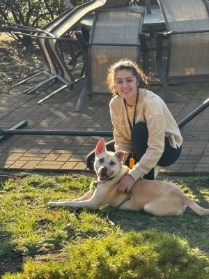 Esther Vergel posing with her dog Amaya outside on the grass