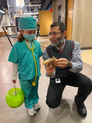 Fawzy Elnady (at right) showing a model to a child dressed as a doctor (at left)