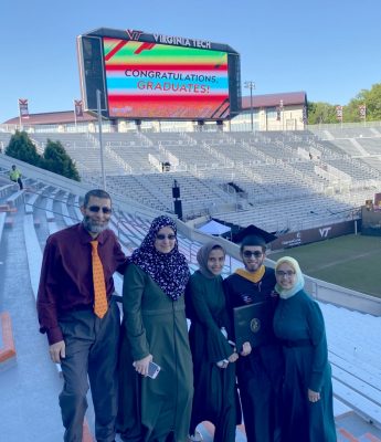 Fawzy Elnady (at left) standing in Lane Stadium with his wife and three children (at right)