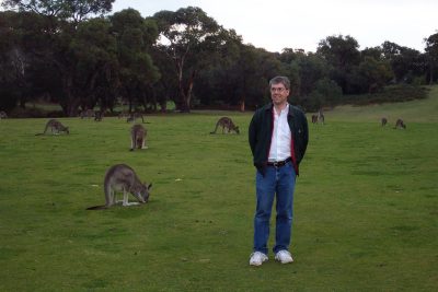 Greg Daniel standing in a field of kangaroos.