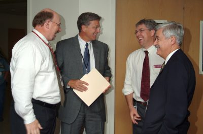 Greg Daniel laughing with several veterinary college administrators.