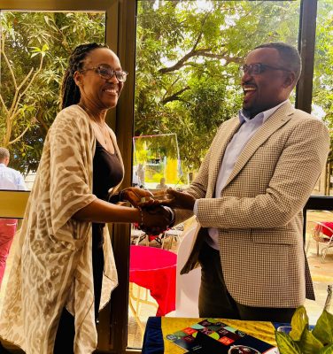 arla Savage receives a commemorative plaque from the president of Jimma University, Dr. Jemal Abafita.