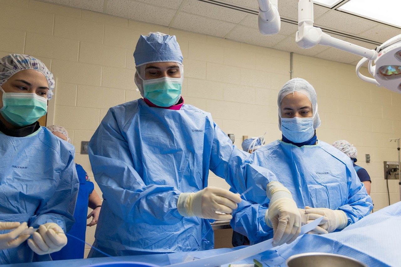 Three veterinary professionals during surgery.