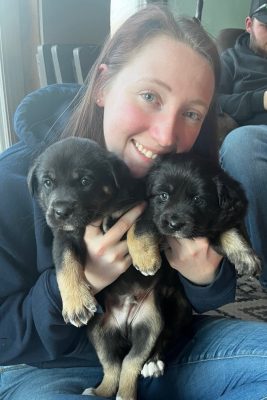 Karson Sluss holding two puppies.