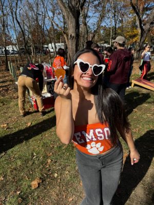 Lauren Maghak standing outside holding a Clemson Tiger paw. 