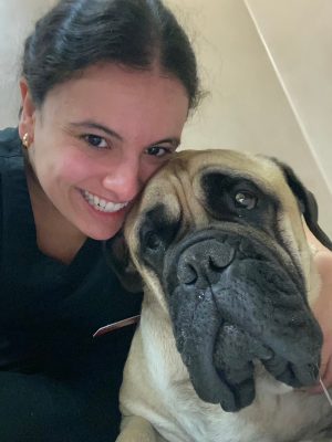 Lauren Maghak (at left) posing with a large dog (at right)