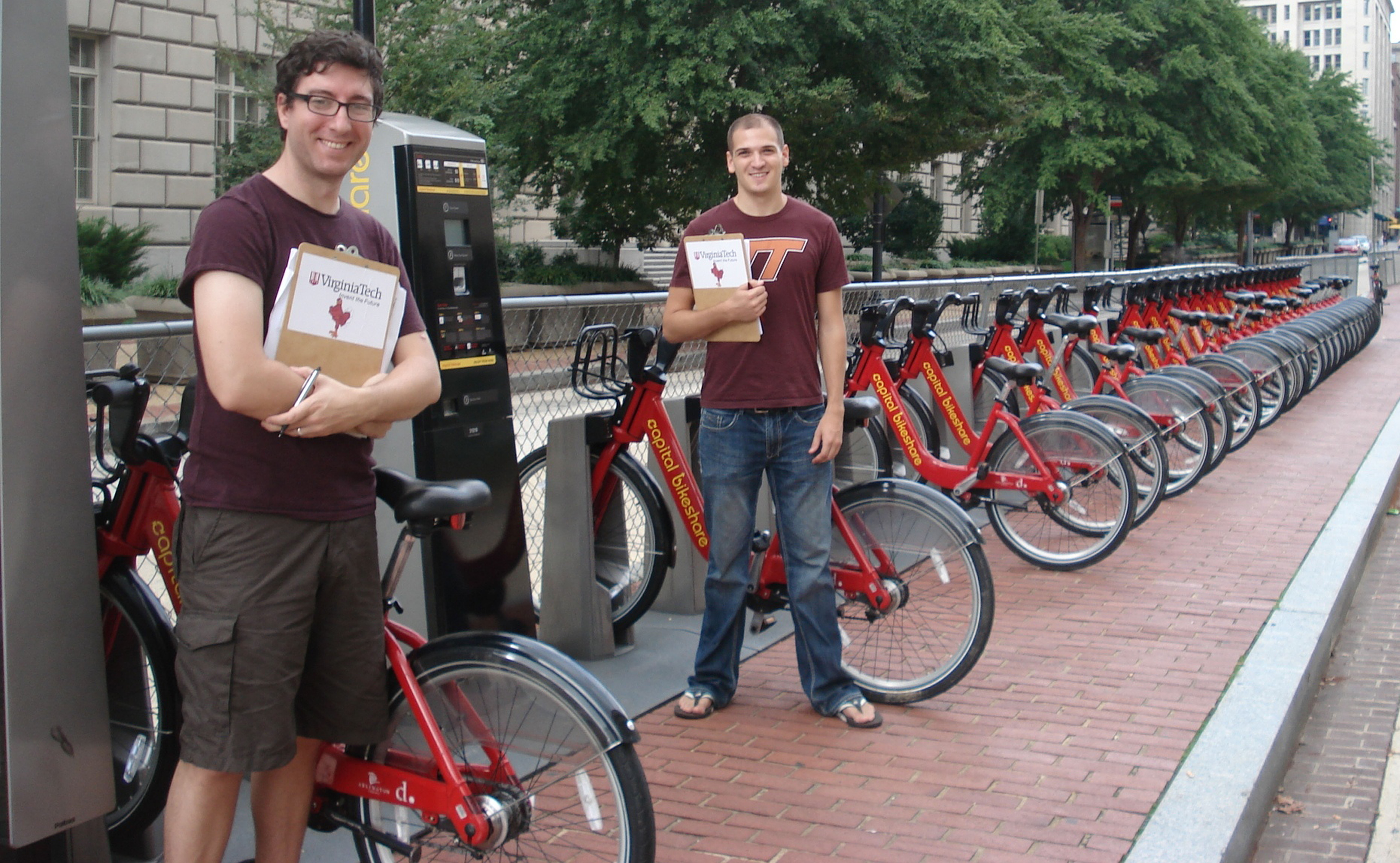 Tim Maher (left) and Austin Watkins (right) stand ready to take surveys at Capital Bikeshare station 