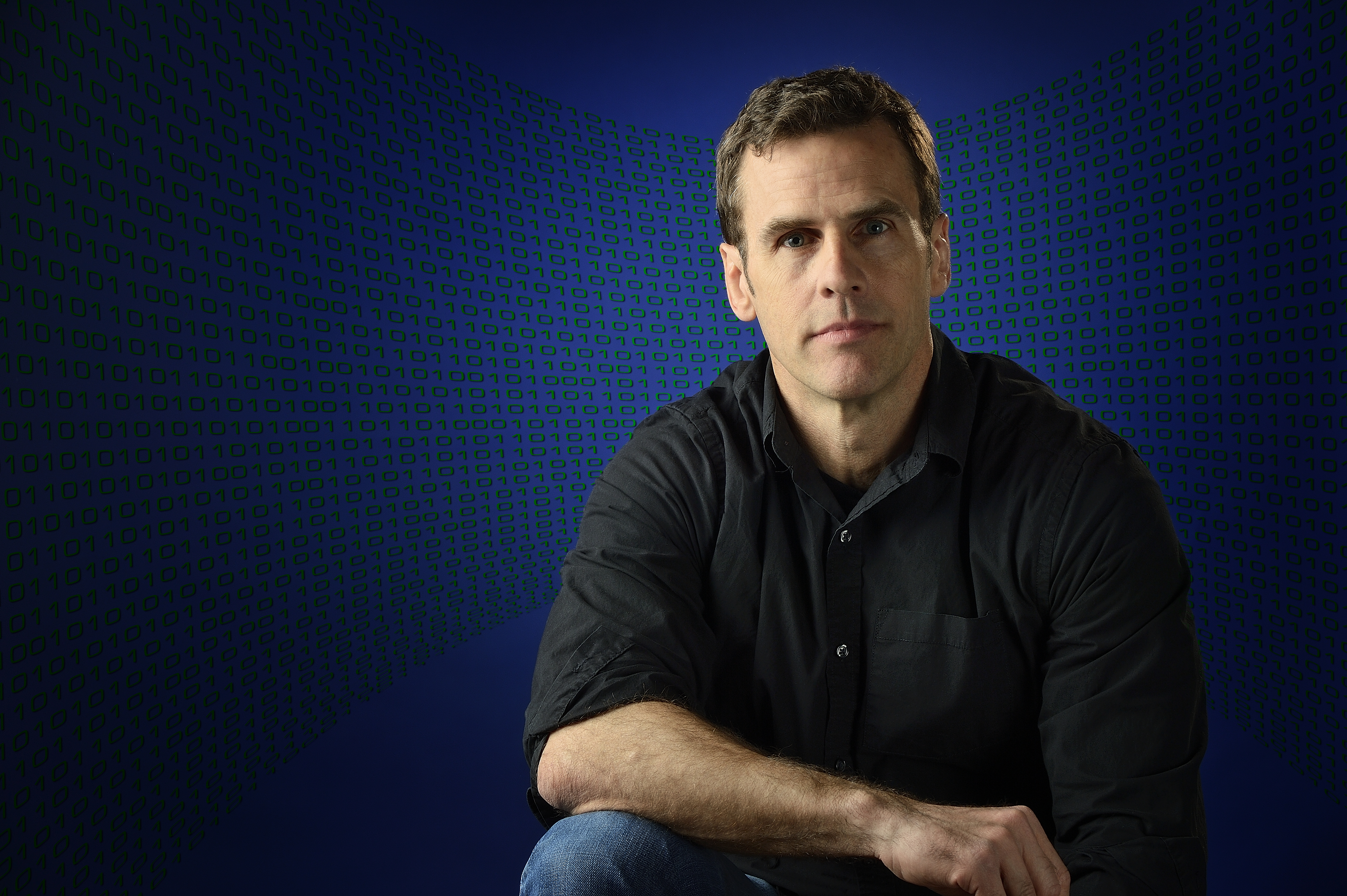portrait of Read Montague with binary code projected behind him