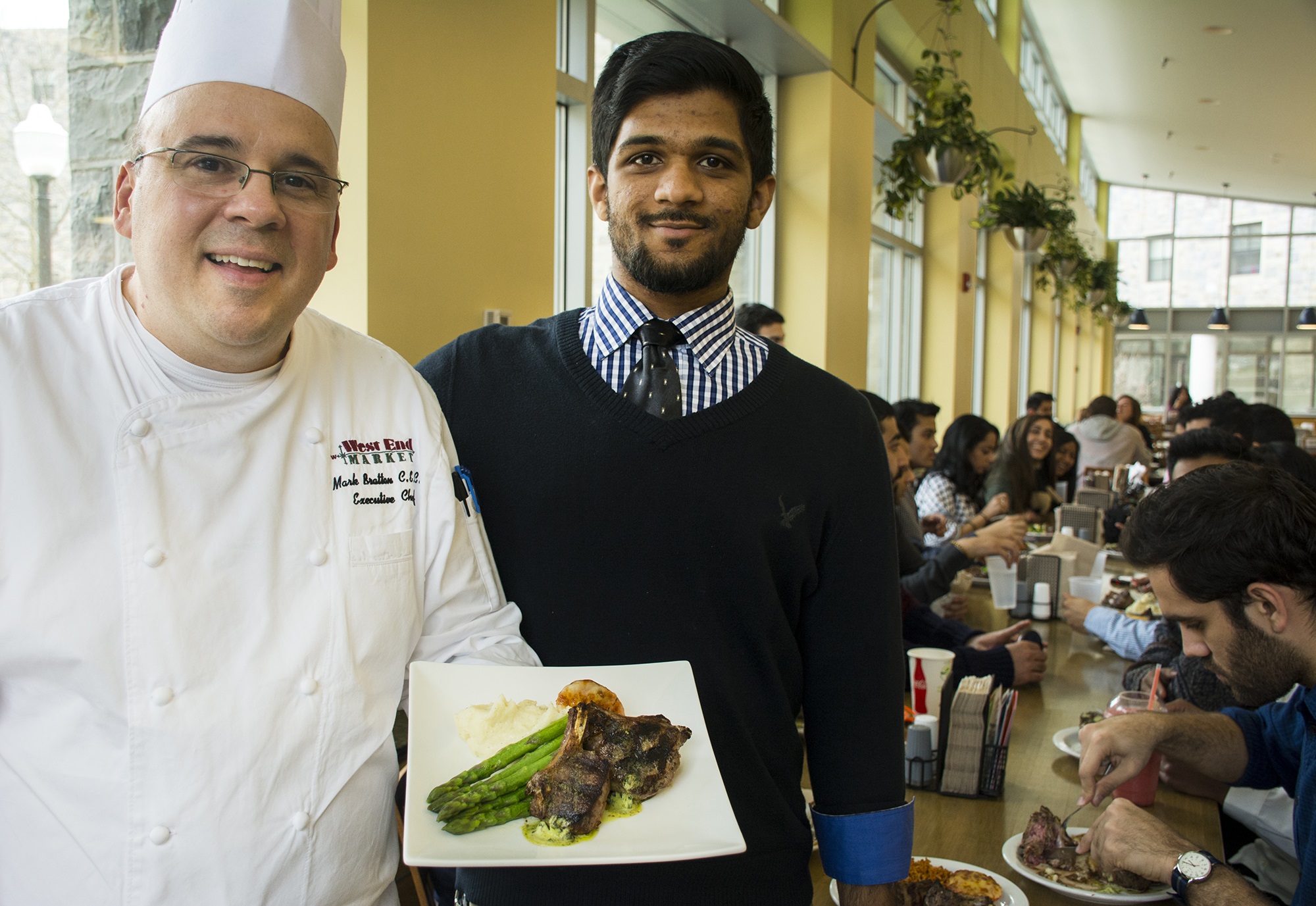 photo of Chef Mark Bratton with meal of Halal lamb. Also seen is Muslim Student Association President Obaid Rehaman.   