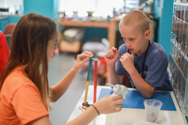 Two students work on a project in a lab.