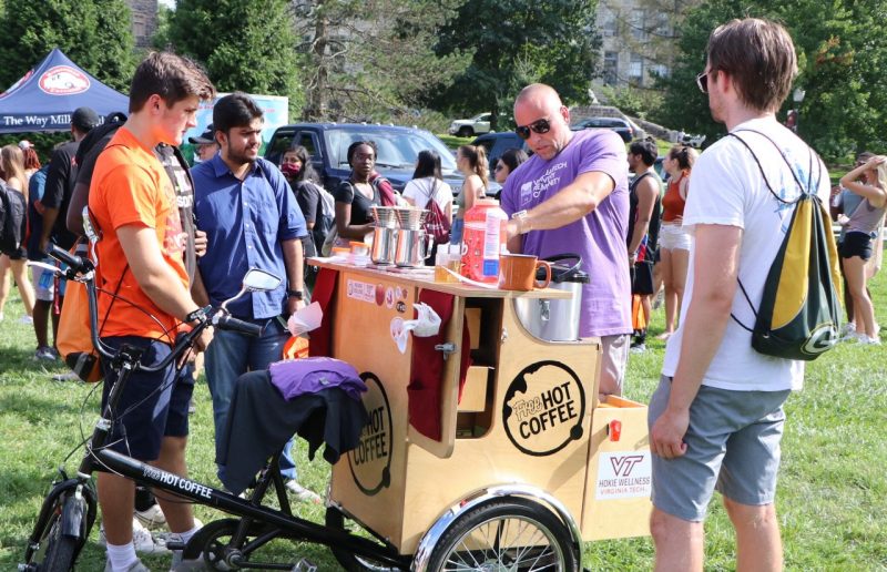 People standing outside around person making coffee bike
