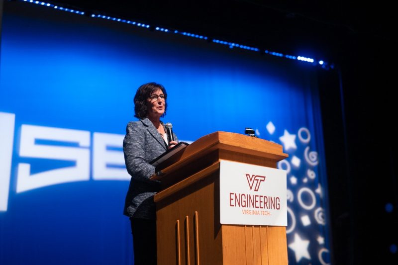 Robyn Gatens stands at a podium with the Virginia Tech Engineering logo on it, speaking through a microphone