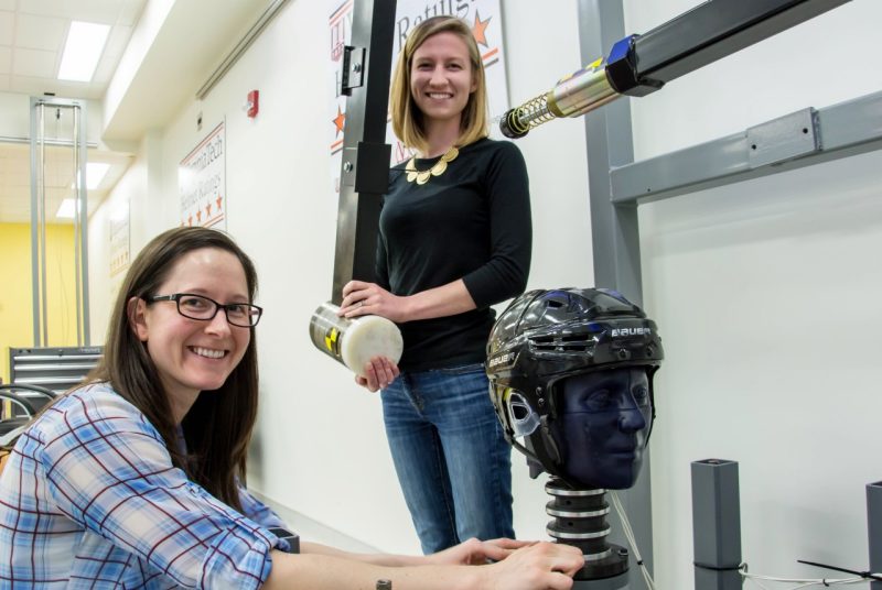 Doctoral student Bethany Rowson, at left, and research associate Abigail Tyson, at right, prepare to test a Bauer hockey helmet.