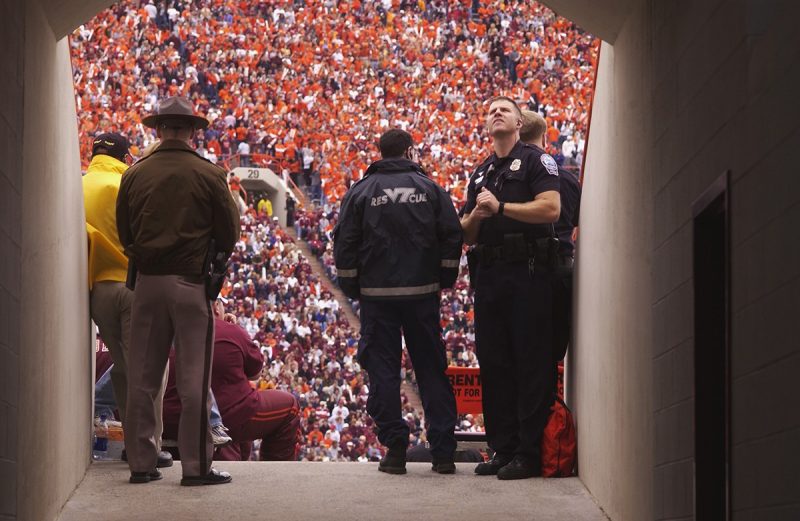 A rescue squad member and other emergency services personnel provides support at home football games