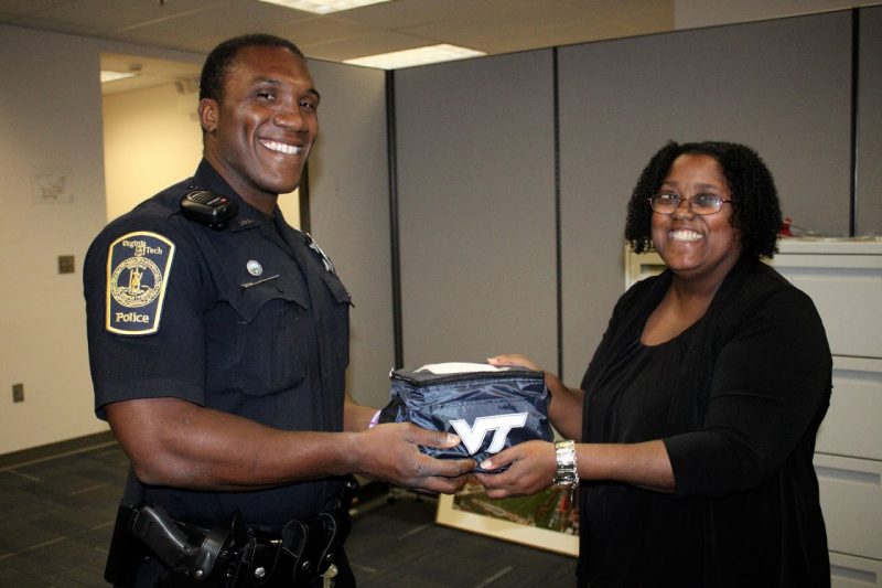 Virginia Tech Police Officer Arkeif Robinson was the first to receive a care cooler from administrative assistant Annabelle Fuselier. Fuselier came up with the idea for Business Services to deliver gifts to the Virginia Tech Police Department.
