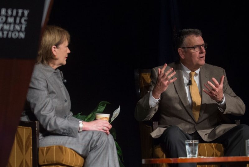 A photo of Nancy Howell Agee and Michael Friedlander sitting on stage and talking.
