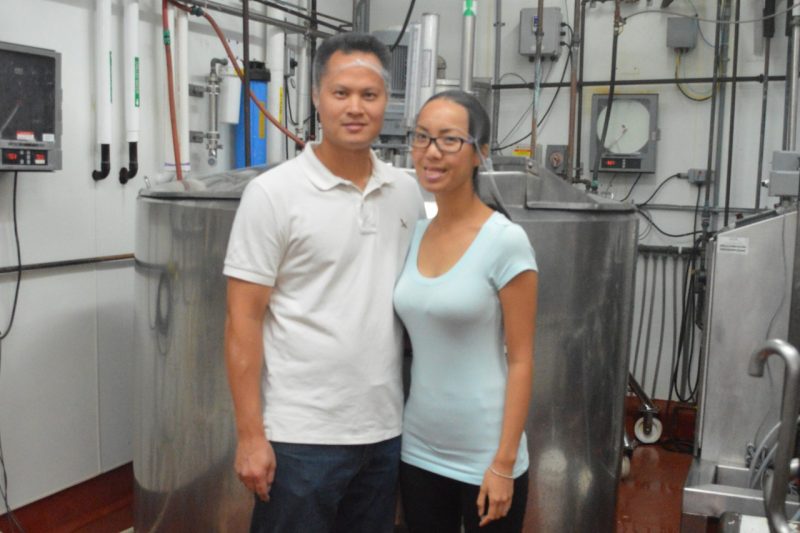 Fred and Phuong Chen are pictures in front of dairy production equipment