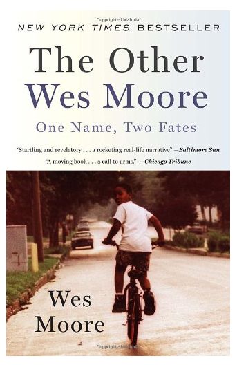 A photo of the cover of the book "The Other Wes Moore," which depicts a young boy riding on a bicyce down a city street looking back