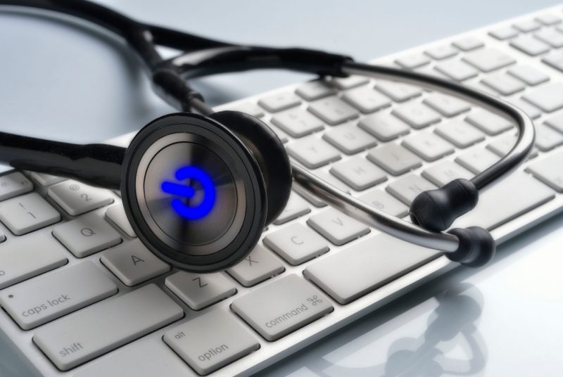 A stethoscope and computer keyboard symbolize the symposium's focus on data analytics as a tool for improving both patient health care and business operations 