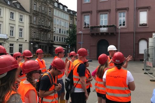 Group of students in hard hats visit construction site in Germany