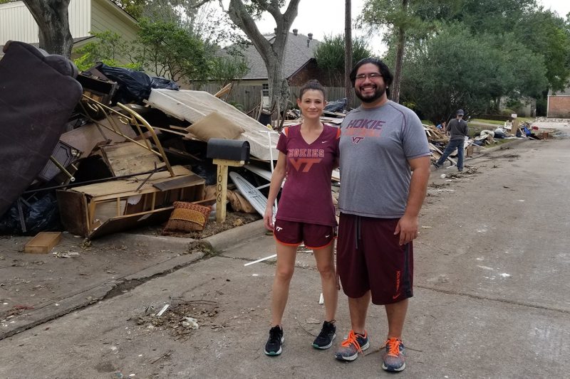Couple standing in a neighborhood damaged by flooding from Hurricane Harvey